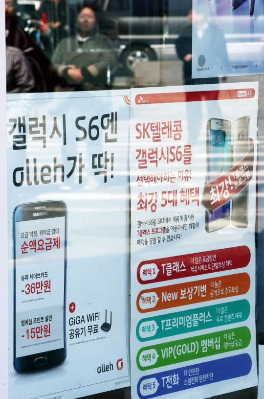 이동통신사가 갤럭시S6 시리즈 출시 일주일 만인 17일 보조금을 최대치인 33만원에 육박할 만큼 파격적으로 올림에 따라 갤럭시S6와 갤럭시S6엣지를 이용한 이동통신사간 가입자 끌어오기 전쟁은 이번 주말 최고조에 달할 것으로 전망된다. 이날 오후 시민들이 서울시내 한 휴대전화 대리점 앞을 지나고 있다.